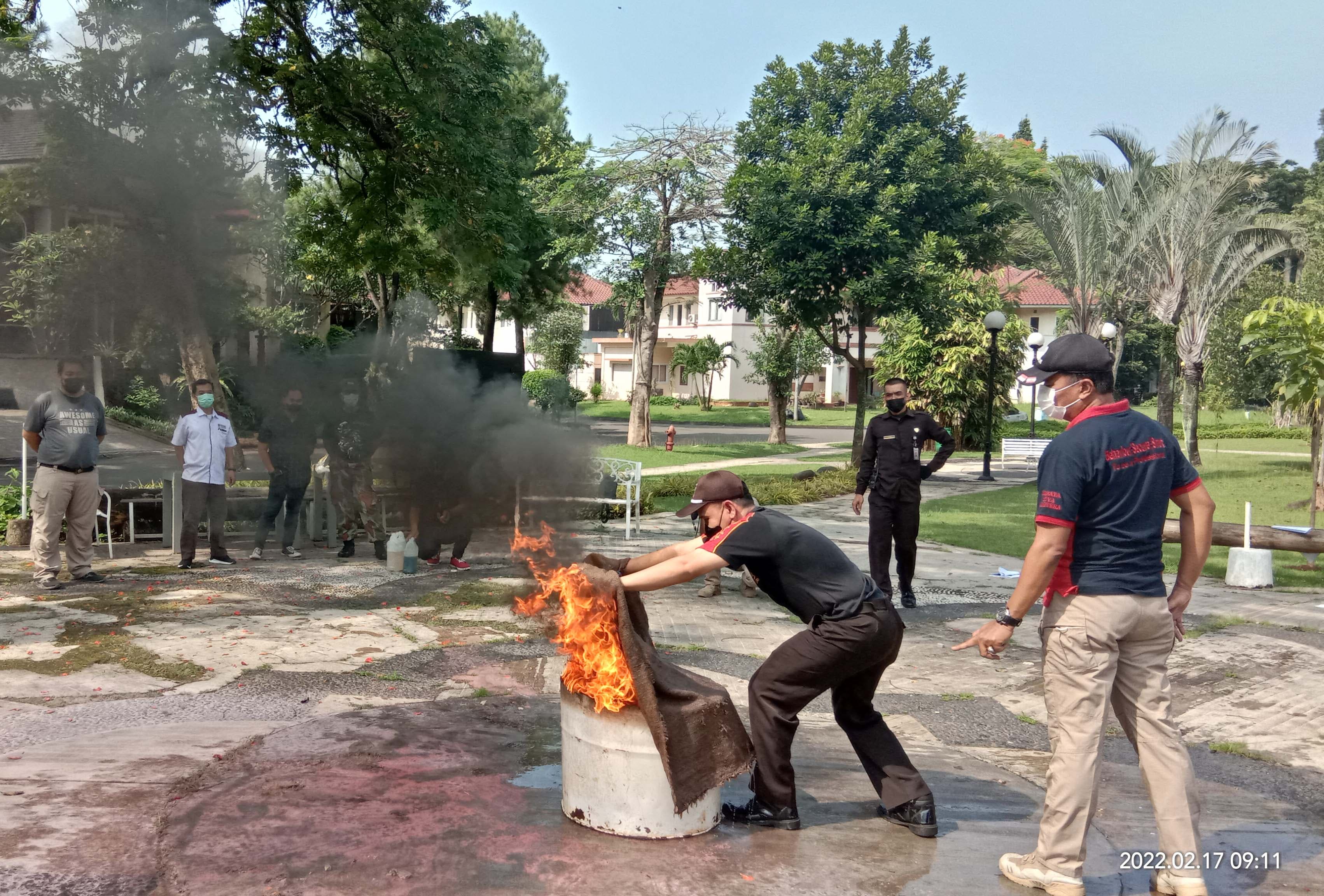 Dua personel satpam di samping lemari perlengkapan pemadam kebakaran